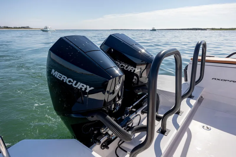 Slide: The Image of 2024 Axopar 28 CABIN with dual Mercury outboard engines on calm water. - 10