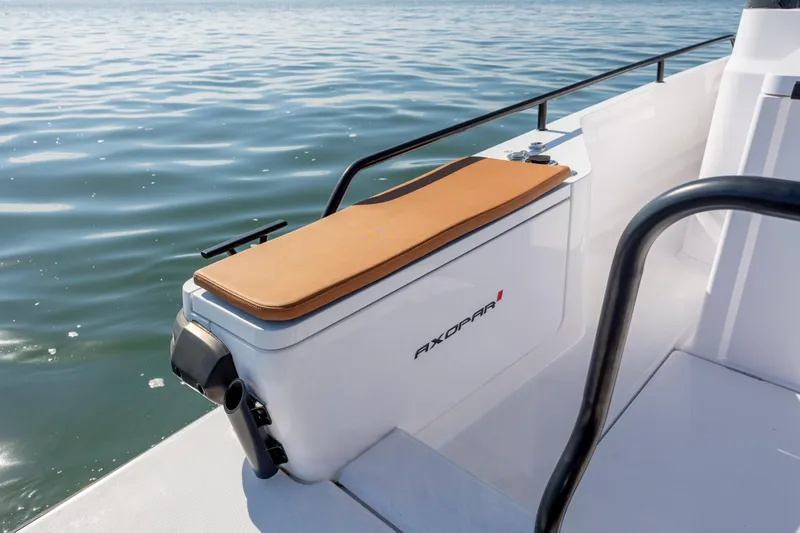 Slide: The Image of 2024 Axopar 28 CABIN boat detail with cushioned seating by the water. - 12