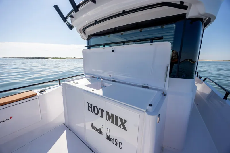 Slide: The Image of 2024 Axopar 28 CABIN boat on water, featuring "HOT MIX" text on deck. - 14
