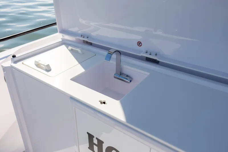 Slide: The Image of 2024 Axopar 28 CABIN boat sink and storage area, featuring sleek design and functionality. - 15
