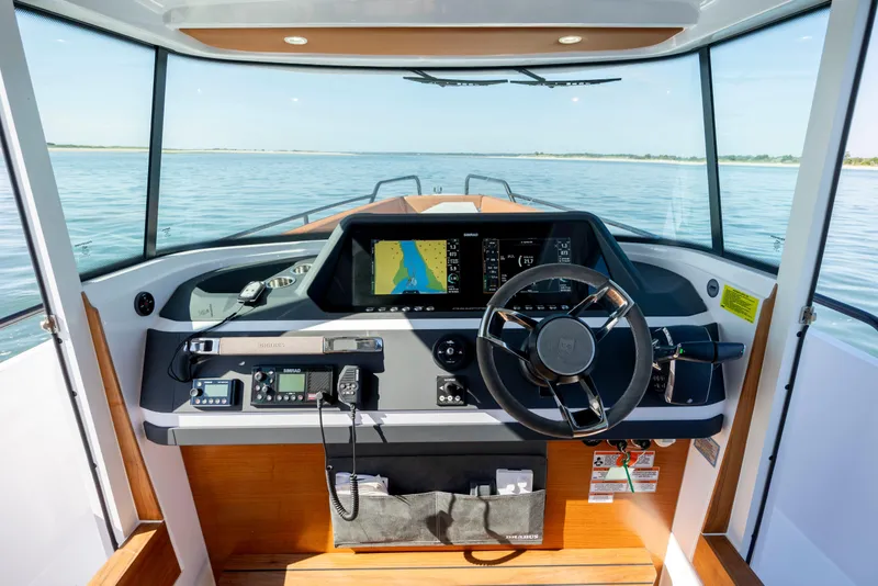 Slide: The Image of 2024 Axopar 28 CABIN boat dashboard with navigation system and steering wheel. - 22