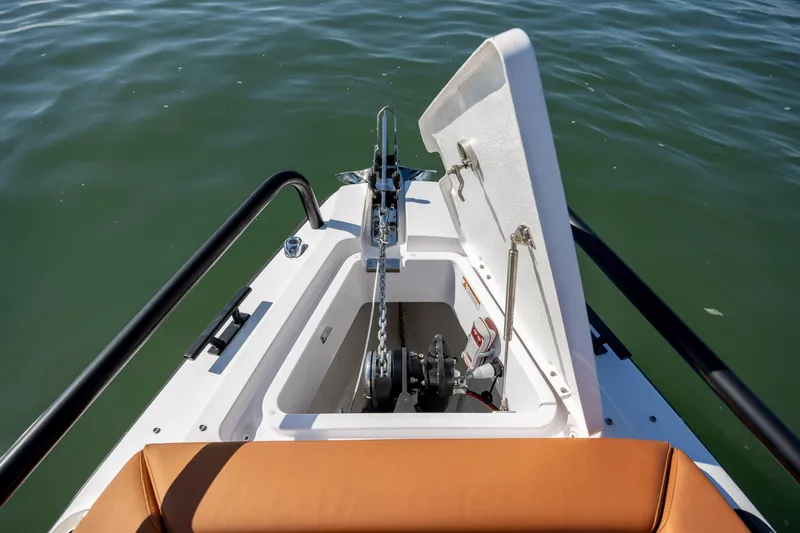 Slide: The Image of 2024 Axopar 28 CABIN anchor compartment with open hatch on calm water. - 31