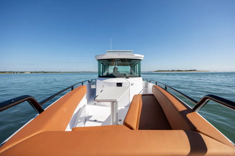 Slide: The Image of 2024 Axopar 28 CABIN boat on calm water, featuring sleek design and comfortable seating. - 32