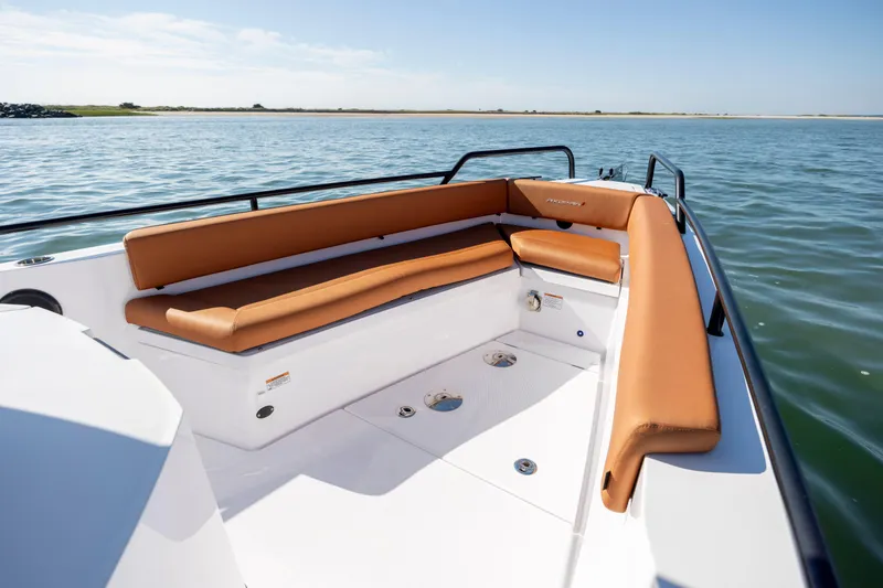 Slide: The Image of 2024 Axopar 28 CABIN boat with tan seating, on calm water. - 34