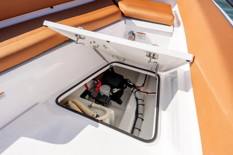 Slide: The Image of 2024 Axopar 28 CABIN storage compartment with open hatch, showcasing interior components and wiring. - 35