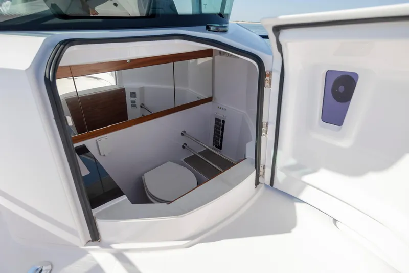Slide: The Image of 2024 Axopar 28 CABIN boat interior with compact bathroom and modern design. - 8