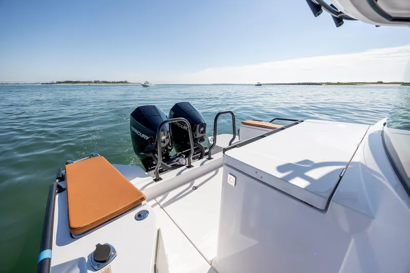 Slide: The Image of 2024 Axopar 28 CABIN boat with dual Mercury engines on calm water. - 9