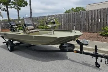Slide: The Image of 2019 Tracker Grizzly 1860 CC boat on trailer, parked on street near wooden fence. - 3