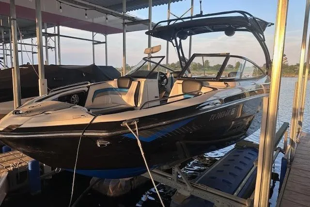 Slide: The Image of 2016 Yamaha Boats 242X E-Series on a lift at a marina. - 3