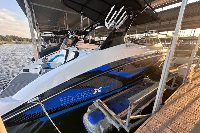 Slide: The Image of 2016 Yamaha Boats 242X E-Series on trailer, parked outdoors, featuring sleek design and vibrant graphics. - 4