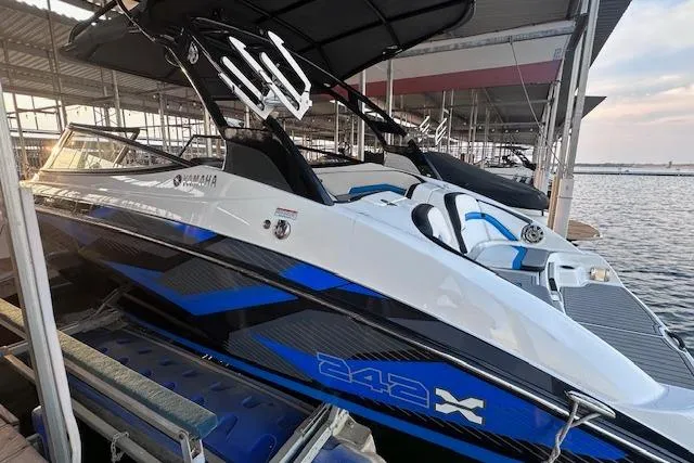Slide: The Image of 2016 Yamaha Boats 242X E-Series docked, featuring sleek design and vibrant blue accents. - 9