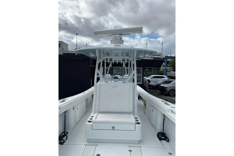 Slide: The Image of 2021 Yellowfin 36 Offshore boat with white seating and radar, under cloudy sky. - 12