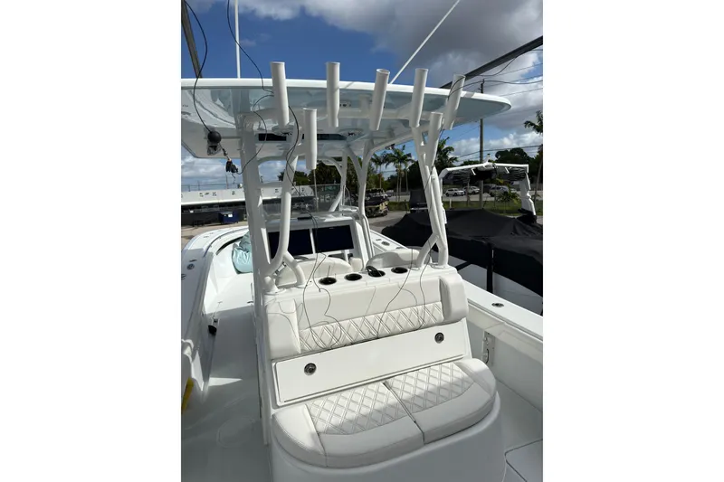 Slide: The Image of 2021 Yellowfin 36 Offshore boat with white seating and rod holders under a blue sky. - 17