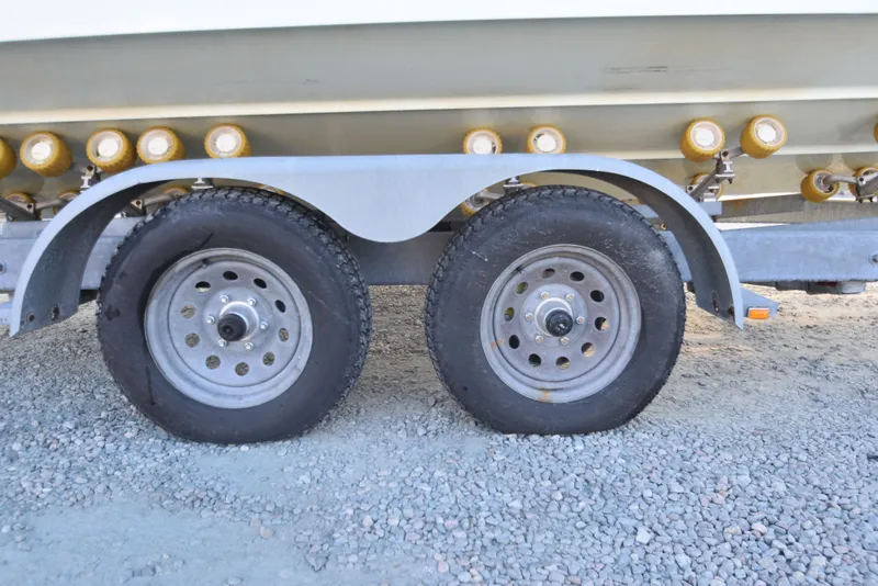 Slide: The Image of Trailer wheels of a 2005 Regulator 24 Forward Seating boat on gravel. - 11