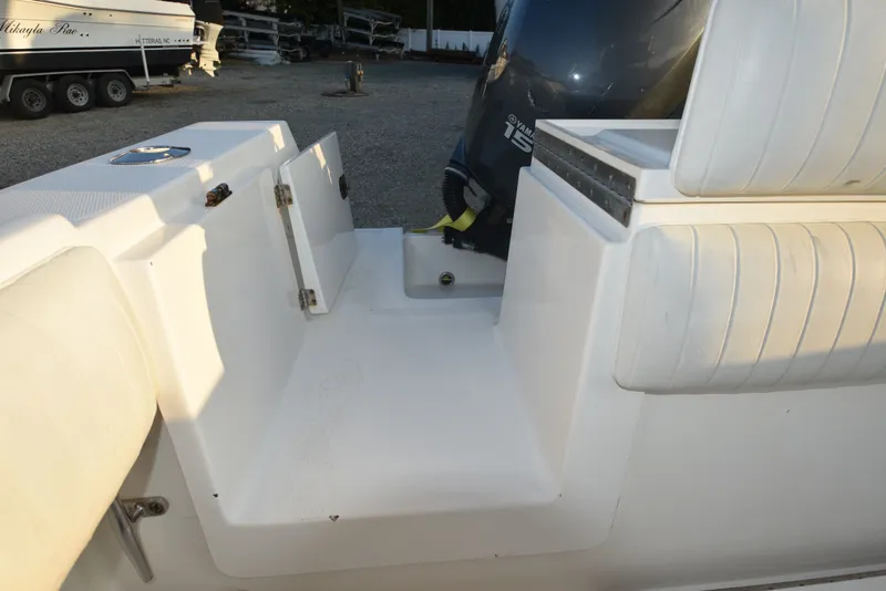 Slide: The Image of 2005 Regulator 24 Forward Seating boat interior with Yamaha 150 engine, white seating, and storage compartments. - 14