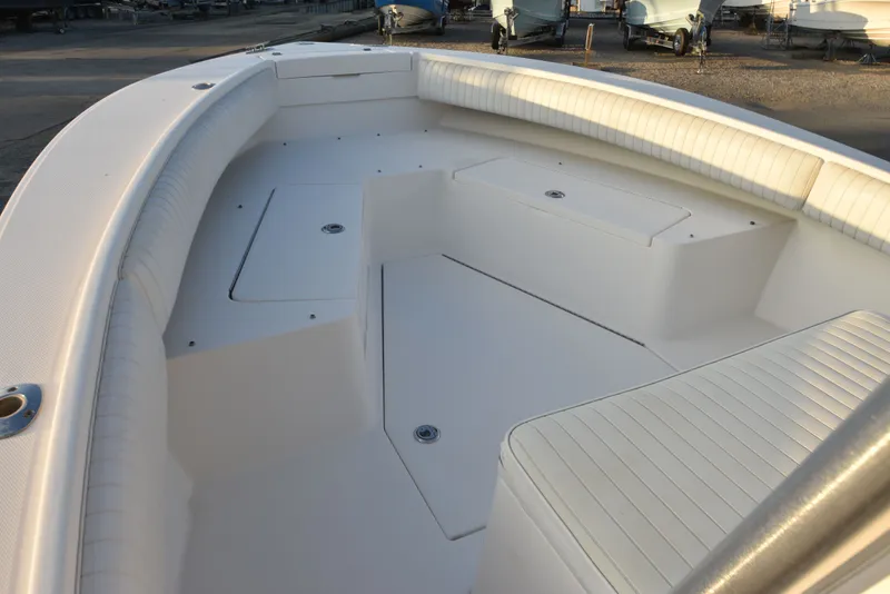 Slide: The Image of 2005 Regulator 24 Forward Seating boat interior with white cushioned seats and storage compartments. - 21