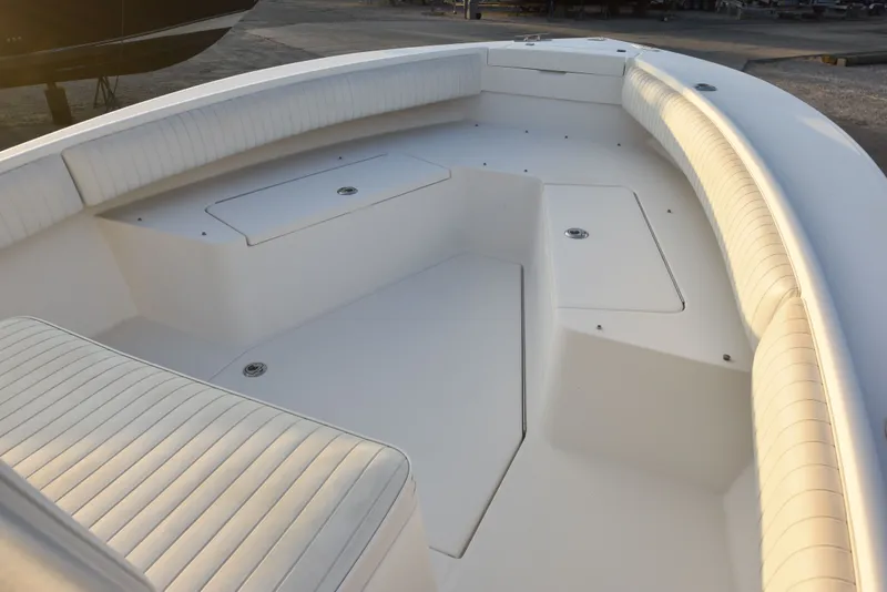 Slide: The Image of 2005 Regulator 24 Forward Seating boat interior with white cushioned seats and storage compartments. - 22