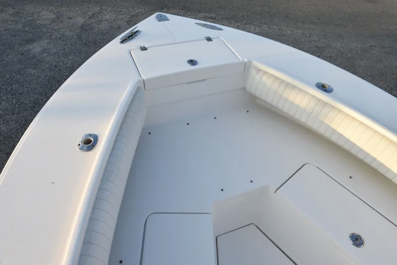 Slide: The Image of 2005 Regulator 24 Forward Seating boat interior with white cushioned seats and storage compartments. - 23