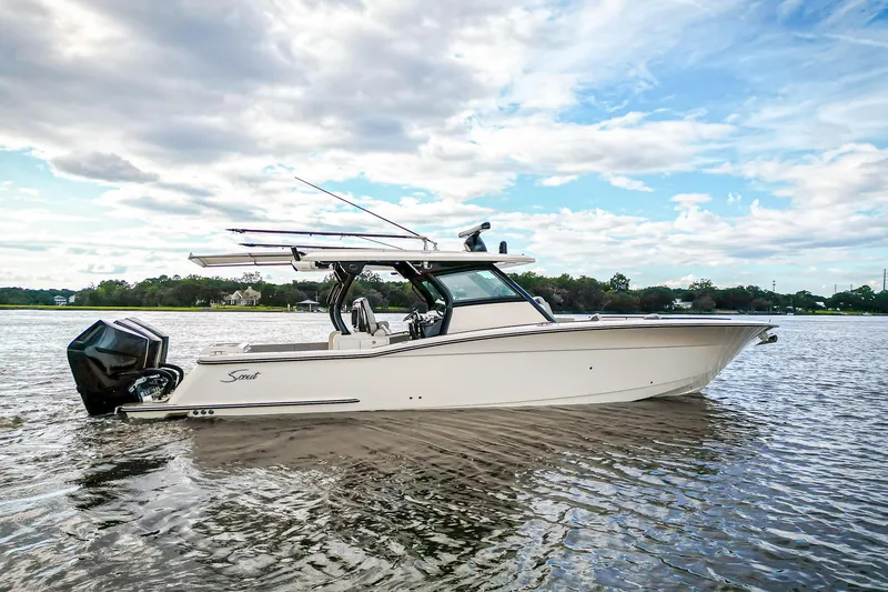 Slide: The Image of 2024 Scout 377 LXF boat on calm water under a partly cloudy sky. - 1