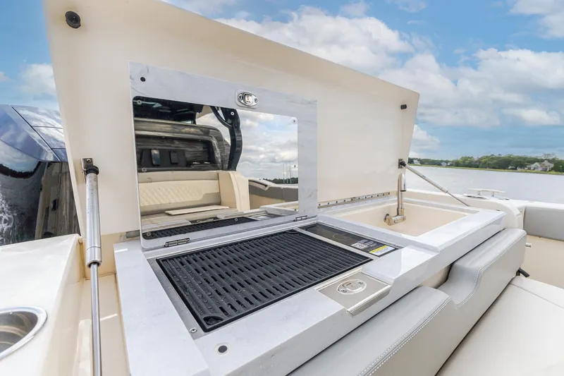 Slide: The Image of 2024 Scout 377 LXF boat with outdoor grill and sink setup. - 18