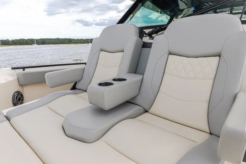 Slide: The Image of Luxurious seating on 2024 Scout 377 LXF boat with cup holders, on a scenic waterway. - 48