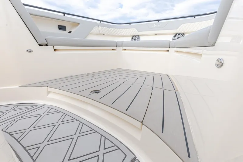 Slide: The Image of 2024 Scout 377 LXF boat interior with cushioned seating and stylish flooring. - 59