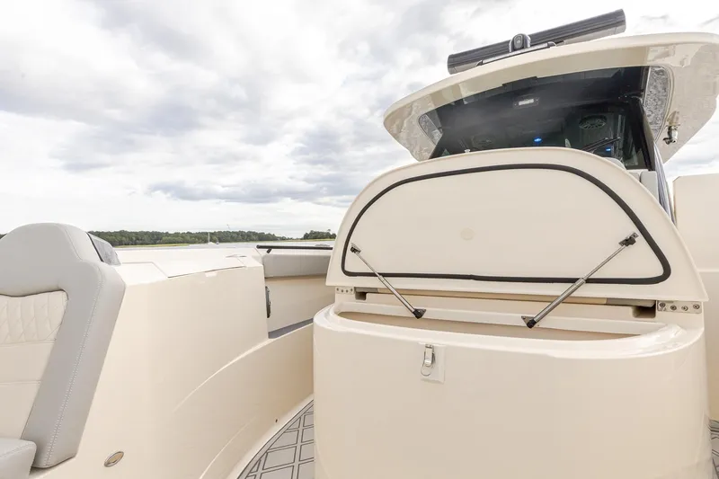 Slide: The Image of 2024 Scout 377 LXF boat interior with open storage compartment under Sunpad - 60