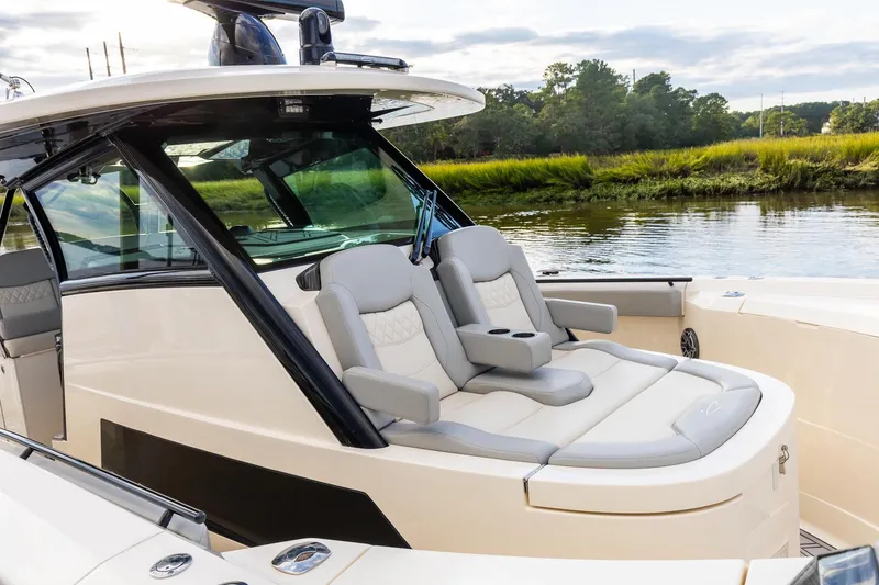 Slide: The Image of 2024 Scout 377 LXF boat interior with luxurious seating by the water. - 71