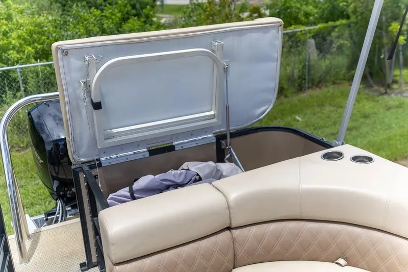 Slide: The Image of 2022 Massimo Marine P-23 MAX Limited boat with open storage compartment and beige seating. - 11