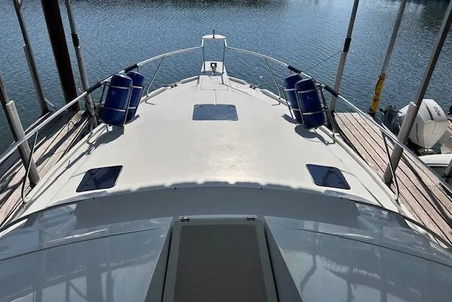 Slide: The Image of 1994 Mainship 40 Sedan Bridge yacht docked, showcasing spacious deck and sleek design. - 10