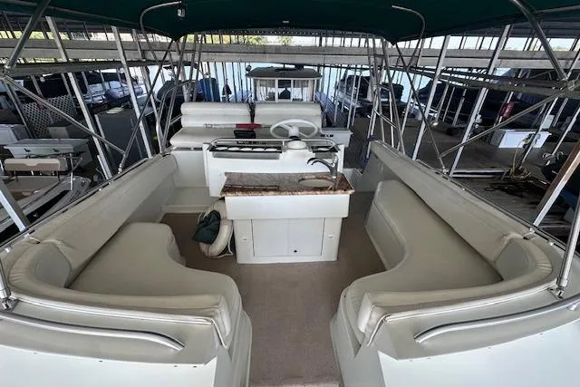 Slide: The Image of 1994 Mainship 40 Sedan Bridge interior with seating and helm, docked in a marina. - 13