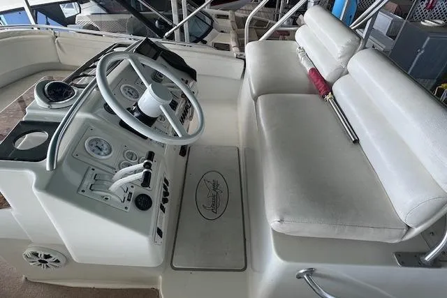 Slide: The Image of 1994 Mainship 40 Sedan Bridge helm with white seating and steering controls. - 15