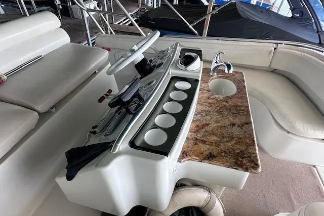 Slide: The Image of 1994 Mainship 40 Sedan Bridge helm with steering wheel, control panel, and granite countertop. - 17