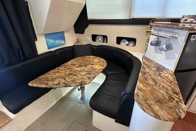 Slide: The Image of 1994 Mainship 40 Sedan Bridge interior with granite countertops and black leather seating. - 19