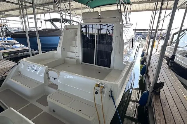 Slide: The Image of 1994 Mainship 40 Sedan Bridge docked in a marina, showcasing spacious deck and sleek design. - 2