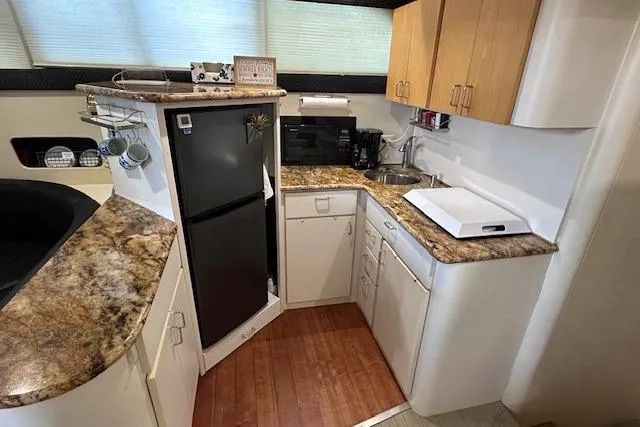 Slide: The Image of 1994 Mainship 40 Sedan Bridge kitchen with modern appliances and wood accents. - 20