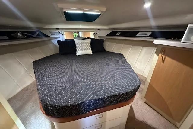 Slide: The Image of 1994 Mainship 40 Sedan Bridge cabin interior with cozy bed and storage. - 23