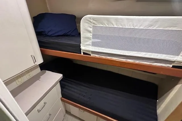 Slide: The Image of 1994 Mainship 40 Sedan Bridge cabin with bunk beds and storage cabinets. - 24
