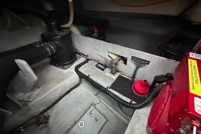 Slide: The Image of Engine compartment of a 1994 Mainship 40 Sedan Bridge with visible hoses and equipment. - 34