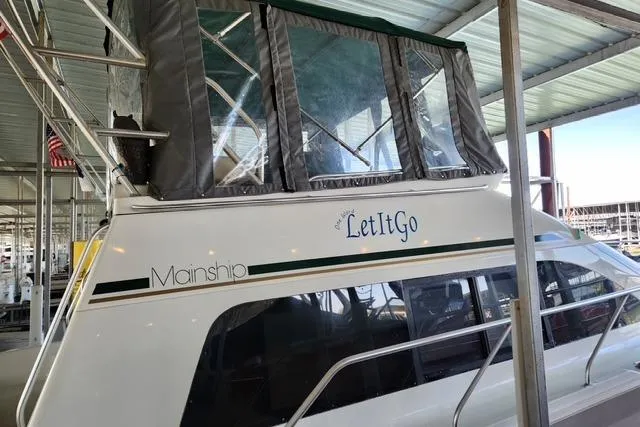 Slide: The Image of 1994 Mainship 40 Sedan Bridge boat named "Let It Go" docked under a covered marina. - 4