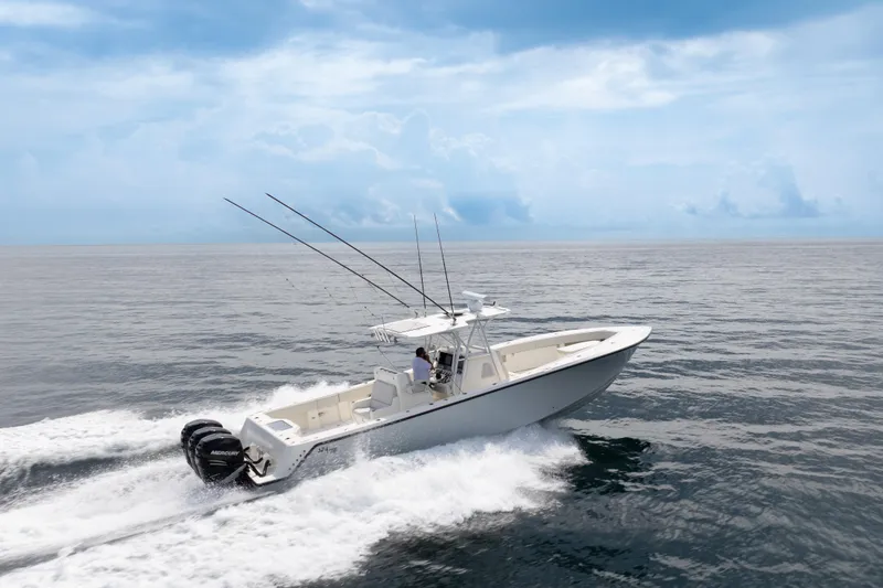 Slide: The Image of 2015 SeaVee 39Z boat on a calm waterway, surrounded by palm trees and luxury homes. - 13