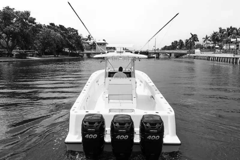 Slide: The Image of 2015 SeaVee 39Z boat interior with white seating and storage, docked on a calm waterway. - 33