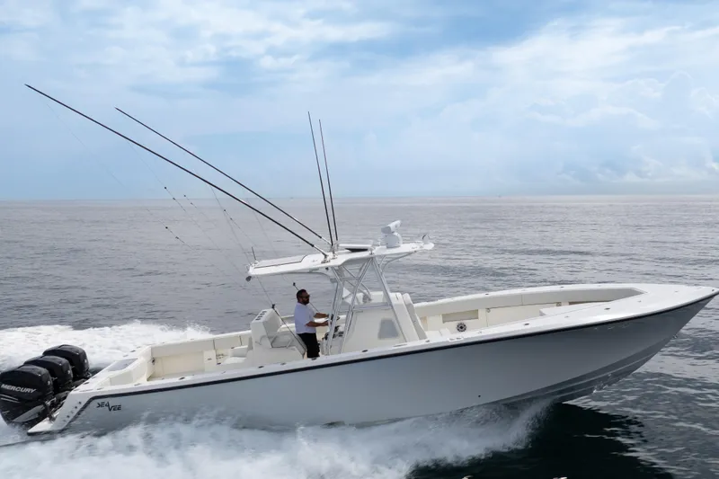 Slide: The Image of 2015 SeaVee 39Z boat cruising on a sunny waterfront with modern buildings. - 5