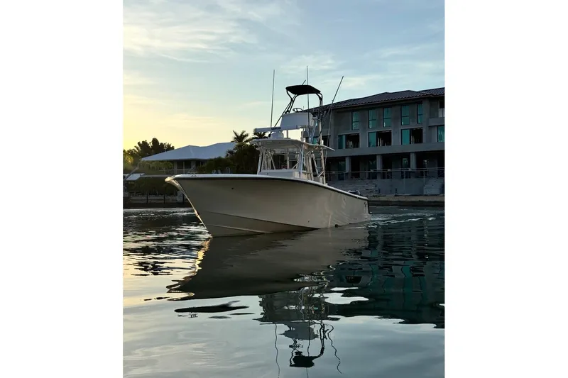 Slide: The Image of 2015 SeaVee 390Z boat on calm water at sunset near modern buildings. - 82