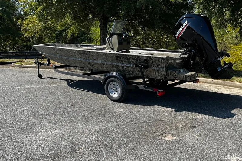 Slide: The Image of 2026 Tracker Grizzly 1860 CC boat with Mercury engine on trailer, parked outdoors. - 3