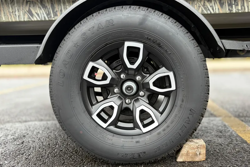 Slide: The Image of 2026 Tracker Grizzly 1650 T Prairie Wings Edition tire on a wooden block. - 36