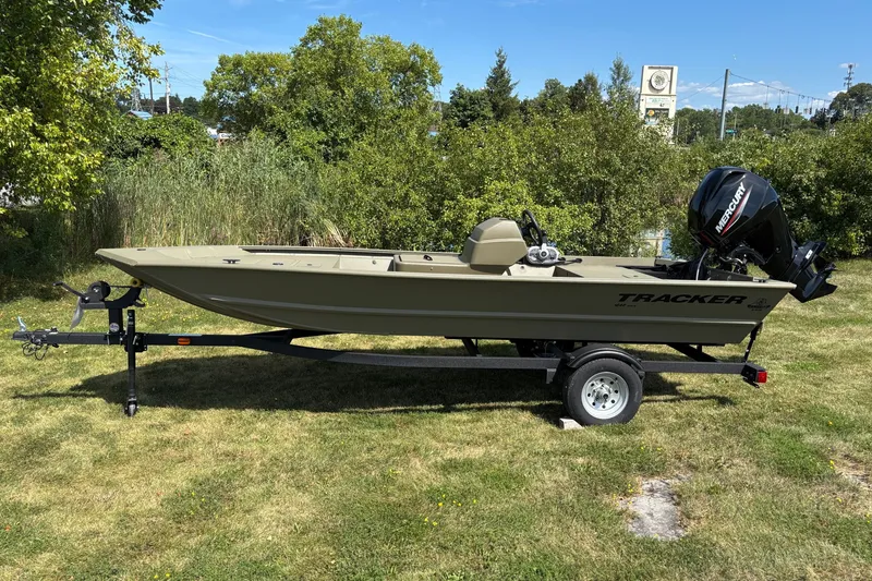 The Image of 2026 Tracker Grizzly 1648 SC boat on trailer, parked on grassy area. - 0