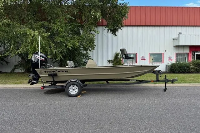 The Image of 2026 Tracker Grizzly 1754 SC boat on trailer, parked outdoors near industrial building. - 0