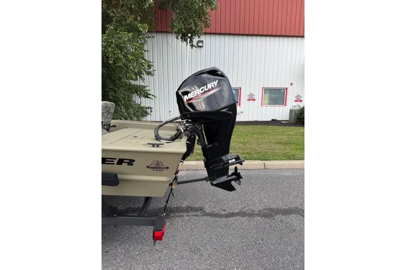 Slide: The Image of 2026 Tracker Grizzly 1754 SC boat with Mercury outboard motor, parked outdoors. - 3