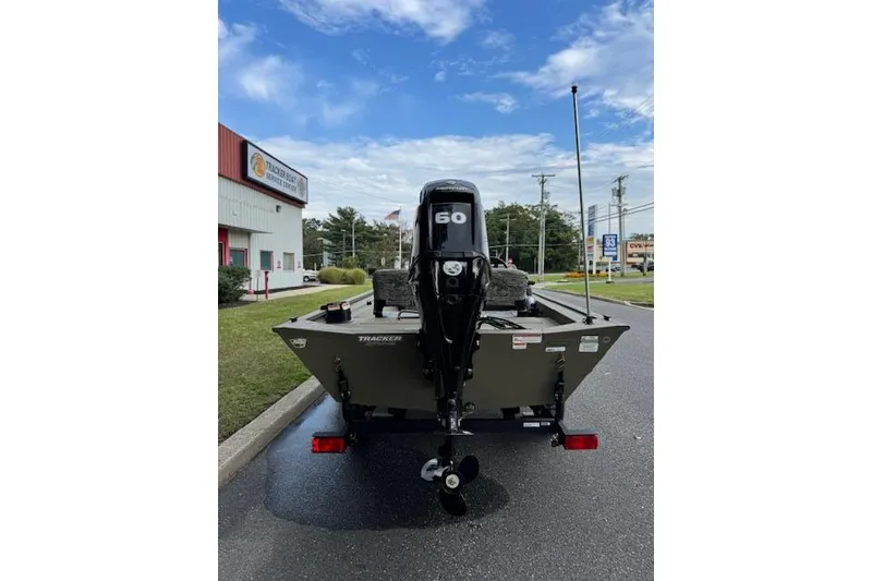 Slide: The Image of 2026 Tracker Grizzly 1754 SC boat with 60 HP motor, parked outdoors. - 6
